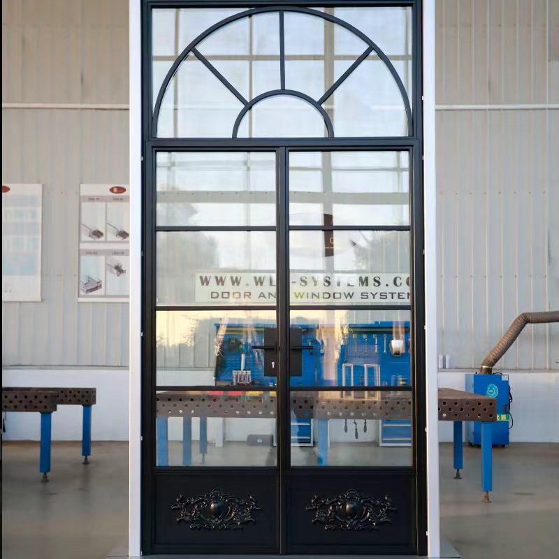 Black steel double doors with an arched glazed fanlight and decorative lower panels